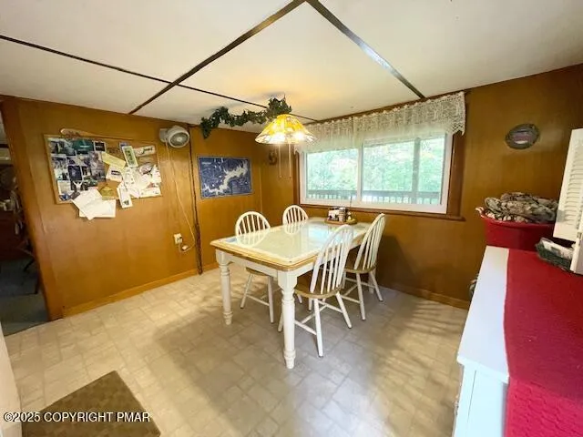 a living room with couches and a dining table with wooden floor