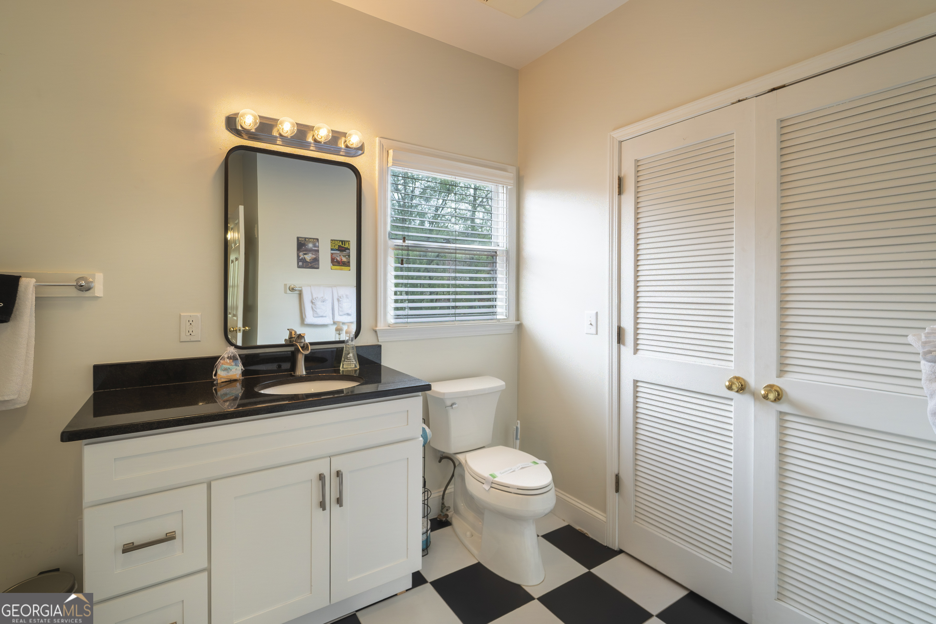 892 Edelweiss Strasse Helen, GA 30545 - Photo 26 of 36 a bathroom with a granite countertop sink toilet a mirror and a shower