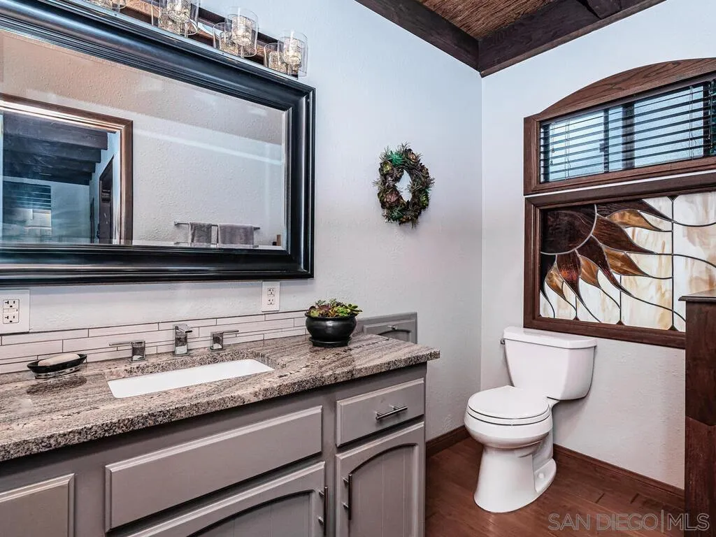 1838 Laurel Road Oceanside, CA 92054 - Photo 27 of 71 a bathroom with a granite countertop toilet sink and mirror