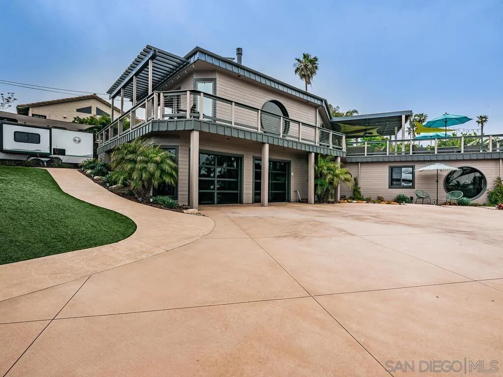 1838 Laurel Road Oceanside, CA 92054 - Photo 28 of 71 a view of a white house with a small yard and large windows