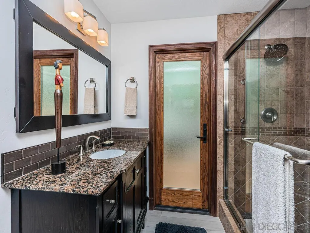 1838 Laurel Road Oceanside, CA 92054 - Photo 40 of 71 a bathroom with a granite countertop sink and a mirror