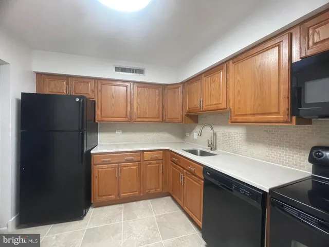 a kitchen with a sink a refrigerator and cabinets