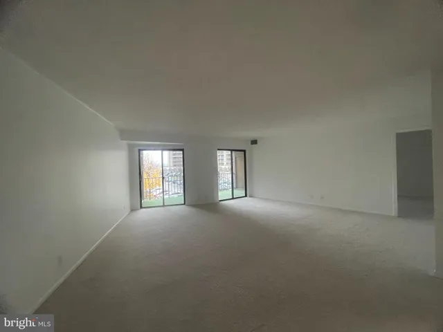 a view of a big room with windows and chandelier fan