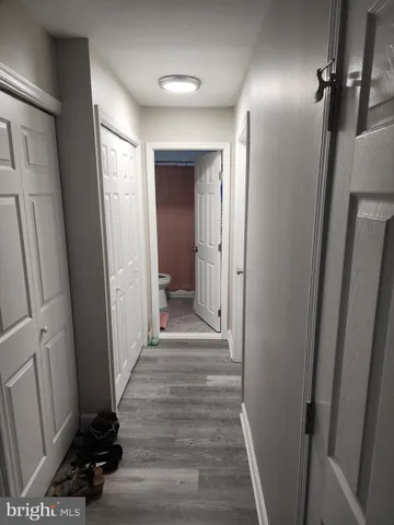 a view of a hallway with wooden floor and closet