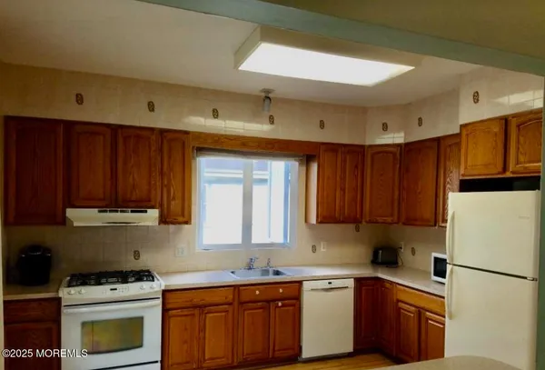 a kitchen with a sink a stove a refrigerator and cabinets