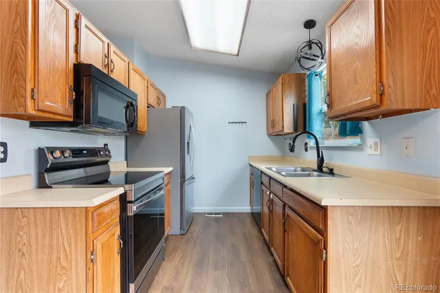 a kitchen with stainless steel appliances granite countertop a sink stove and refrigerator