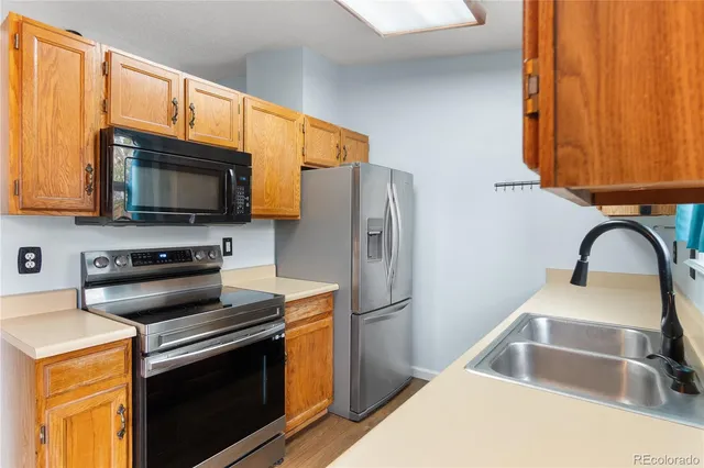 a kitchen with stainless steel appliances granite countertop a stove microwave refrigerator and sink