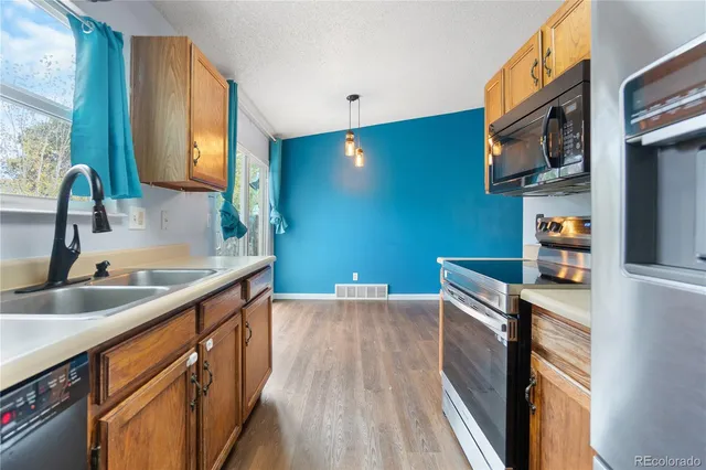 a view of a kitchen with a sink and wooden floor
