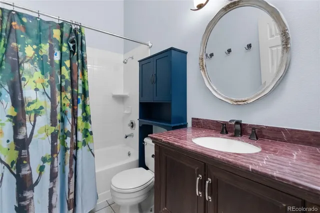 a bathroom with a granite countertop sink a toilet and a mirror