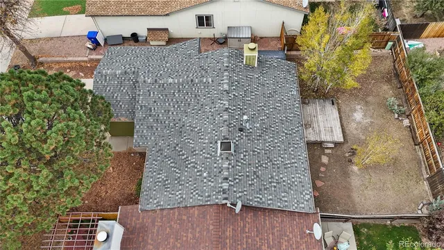 an aerial view of a house with a yard and large trees
