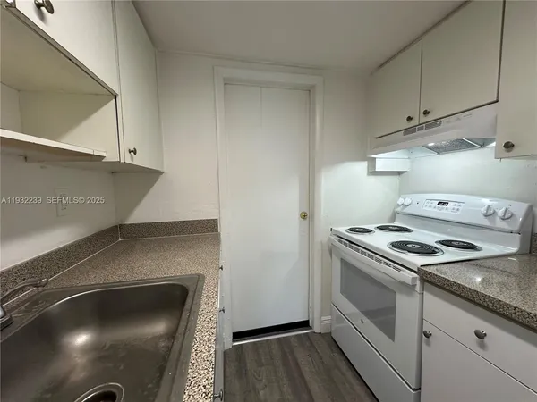 a kitchen with granite countertop a stove and a sink