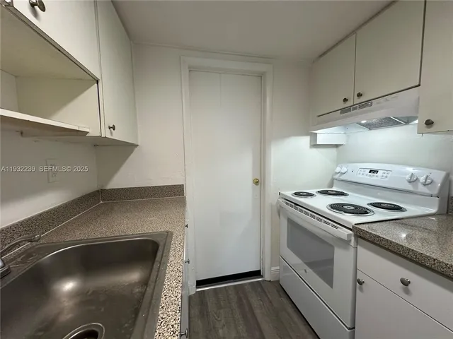 a kitchen with granite countertop a stove and a sink