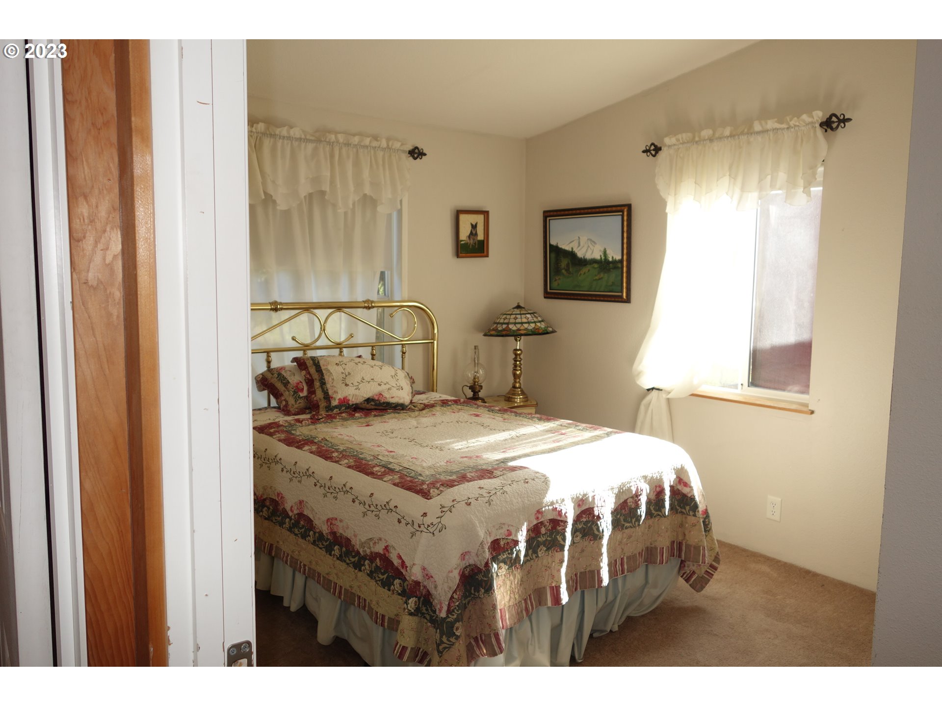 182 Bates Road White Salmon, WA 98672 - Photo 24 of 38 a bedroom with a bed a lamp and a window