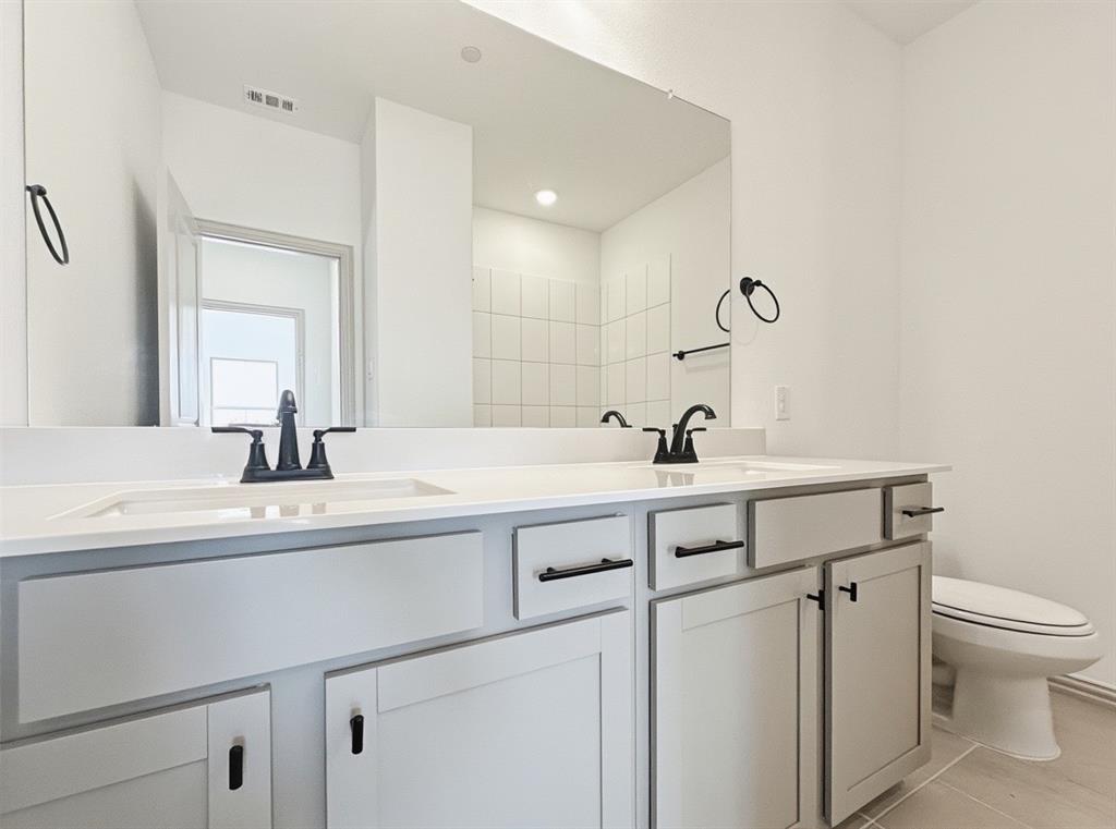 2837 Bluejack Road McKinney, TX 75071 - Photo 27 of 40 a bathroom with a sink a toilet and a mirror
