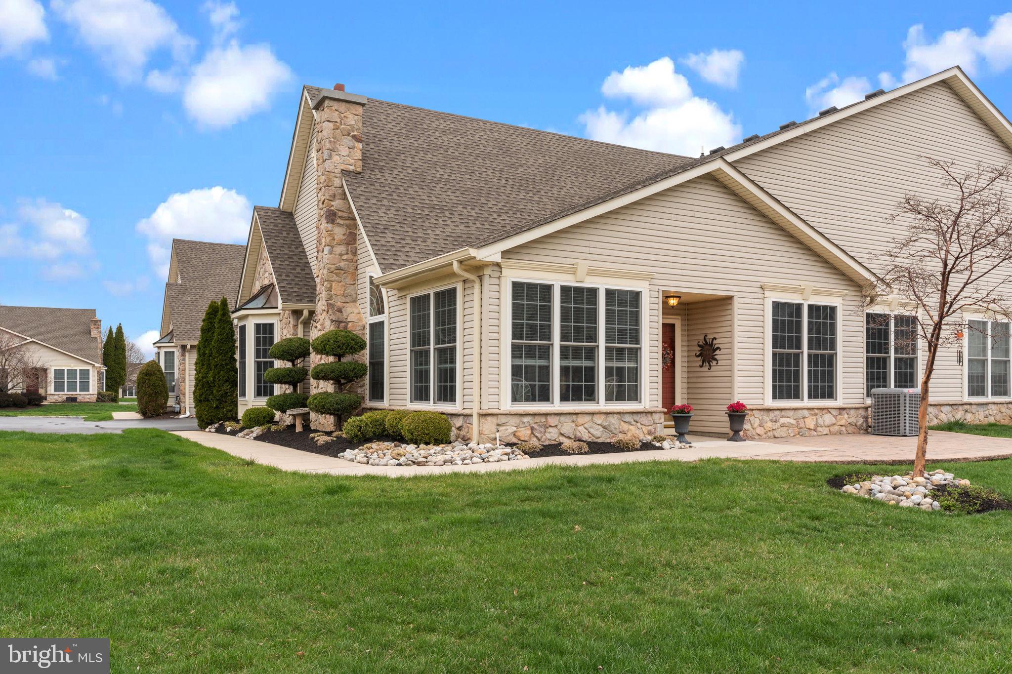 a front view of a house with a yard and outdoor seating