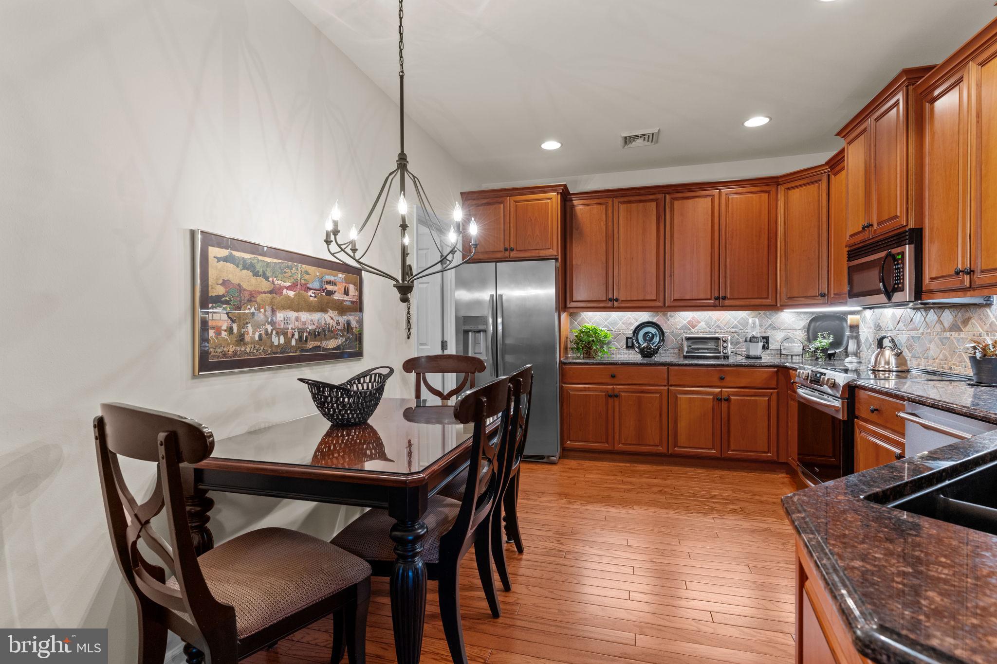613 Bellflower Road Langhorne, PA 19047 - Photo 12 of 28 a kitchen with granite countertop a dining table chairs stainless steel appliances and cabinets