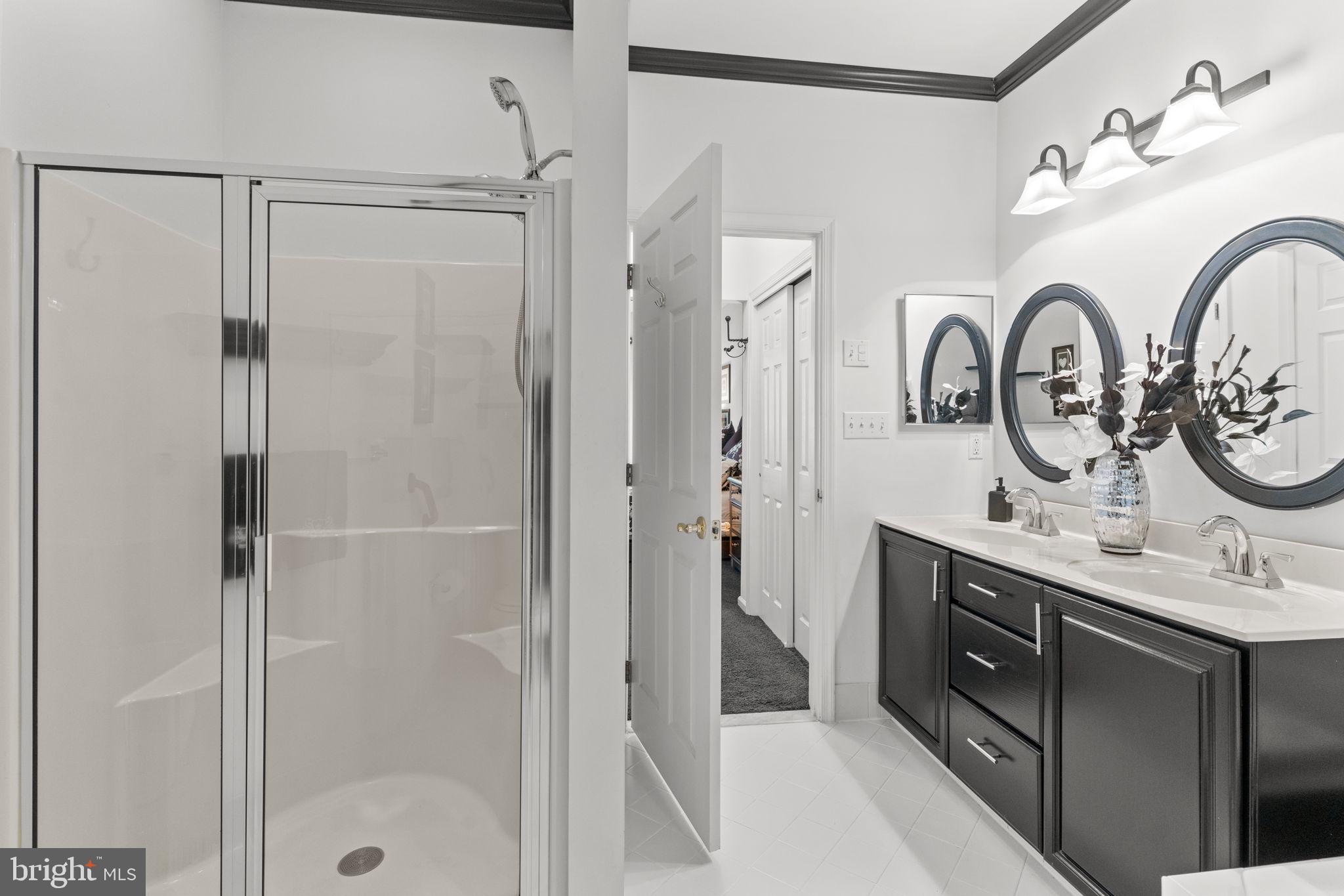 613 Bellflower Road Langhorne, PA 19047 - Photo 21 of 28 a bathroom with a double vanity sink a toilet a shower and a mirror