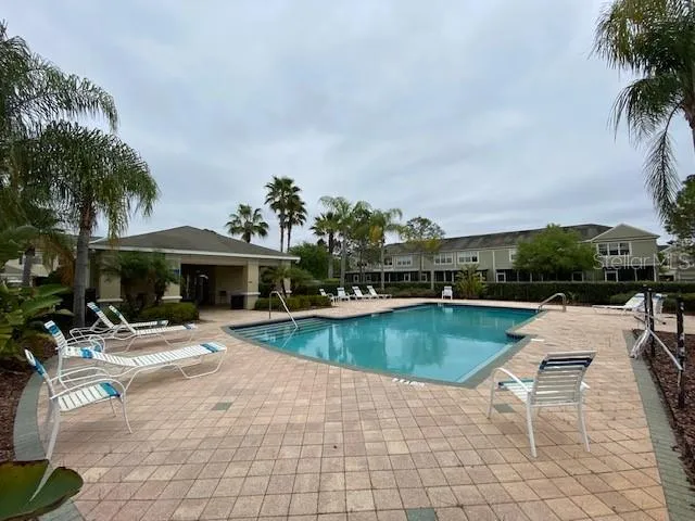 a view of a swimming pool with lounge chairs in patio
