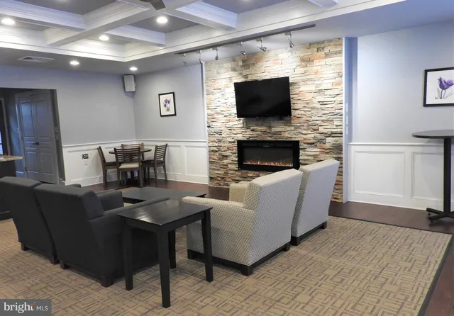 a living room with furniture a flat screen tv and a fireplace