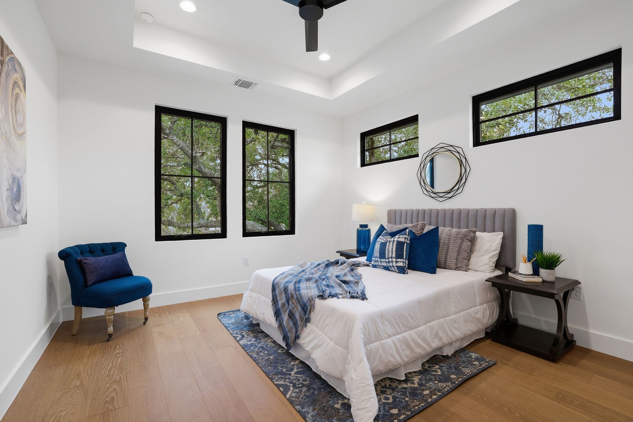 6611 Lexington Road Austin, TX 78757 - Photo 23 of 37 Bright bedroom featuring wood-finish flooring, white walls, and a tray ceiling with recessed lighting