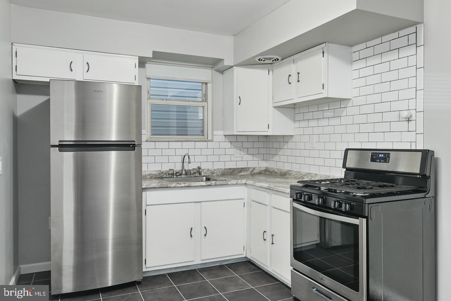a kitchen with cabinets stainless steel appliances and sink