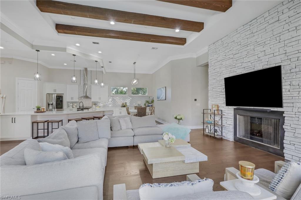 5074 Rustic Oaks Circle Naples, FL 34105 - Photo 12 of 38 a living room with fireplace furniture and a flat screen tv