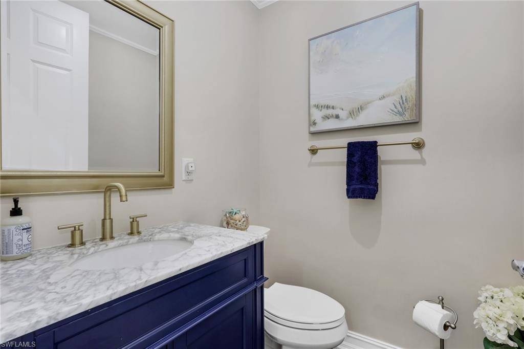 5074 Rustic Oaks Circle Naples, FL 34105 - Photo 15 of 38 a bathroom with a granite countertop sink mirror vanity and toilet