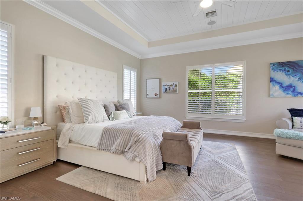 5074 Rustic Oaks Circle Naples, FL 34105 - Photo 16 of 38 Bedroom with dark wood-style floors, ornamental molding, wood ceiling, ceiling fan, and a raised ceiling