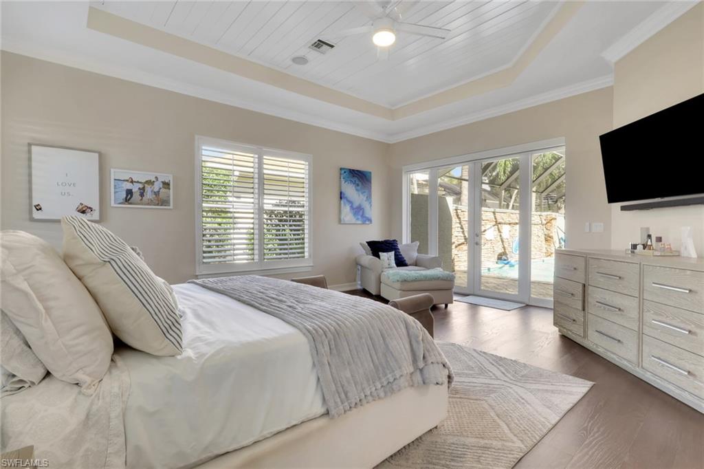 5074 Rustic Oaks Circle Naples, FL 34105 - Photo 17 of 38 Bedroom featuring a tray ceiling, access to exterior, wood finished floors, wood ceiling, and ceiling fan
