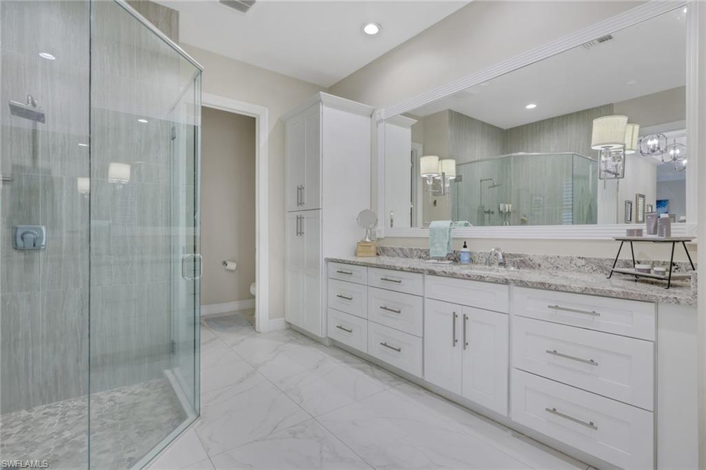 5074 Rustic Oaks Circle Naples, FL 34105 - Photo 19 of 38 Bathroom with vanity, light marble finish floors, and a shower stall