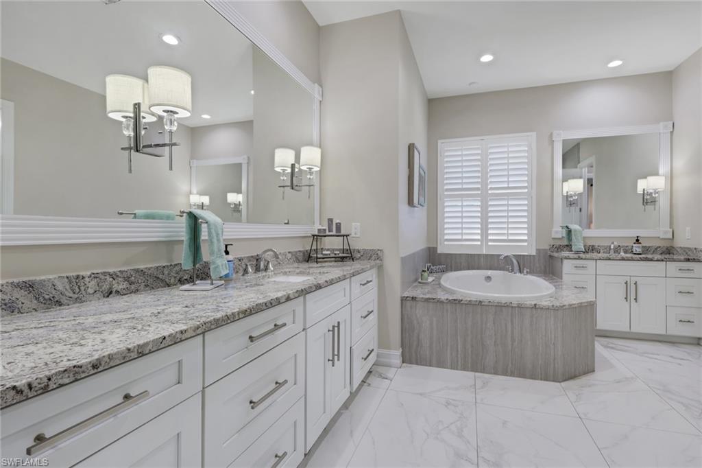 5074 Rustic Oaks Circle Naples, FL 34105 - Photo 21 of 38 a bathroom with a granite countertop double vanity sink a bathtub and shower