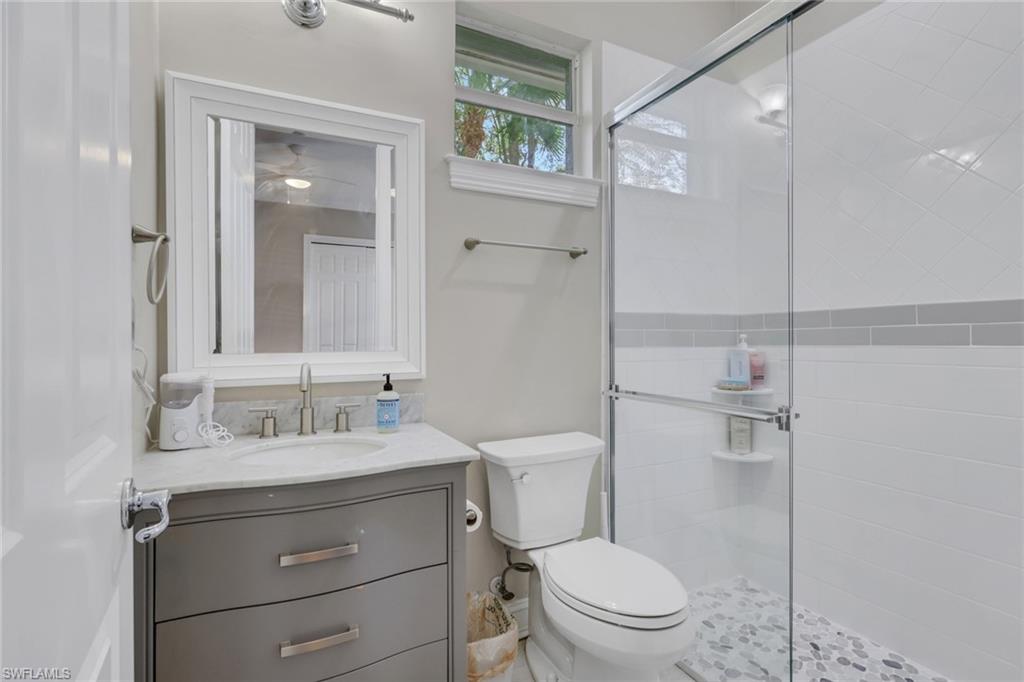 5074 Rustic Oaks Circle Naples, FL 34105 - Photo 23 of 38 a bathroom with a sink a toilet a mirror and shower