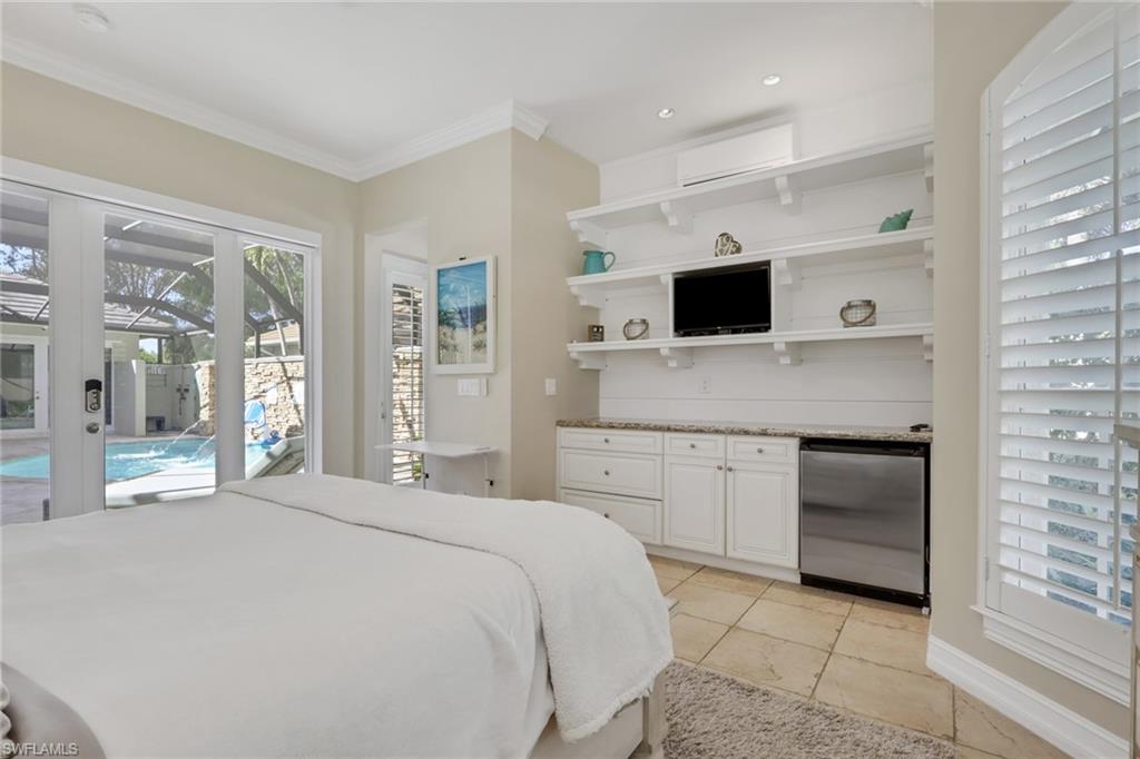 5074 Rustic Oaks Circle Naples, FL 34105 - Photo 25 of 38 Bedroom featuring multiple windows, access to outside, stainless steel fridge, a wall unit AC, and crown molding