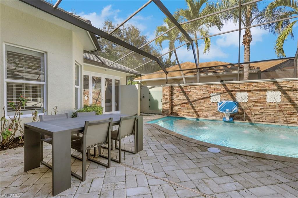 5074 Rustic Oaks Circle Naples, FL 34105 - Photo 30 of 38 View of swimming pool featuring a patio area, a sunroom, a lanai, and outdoor dining area