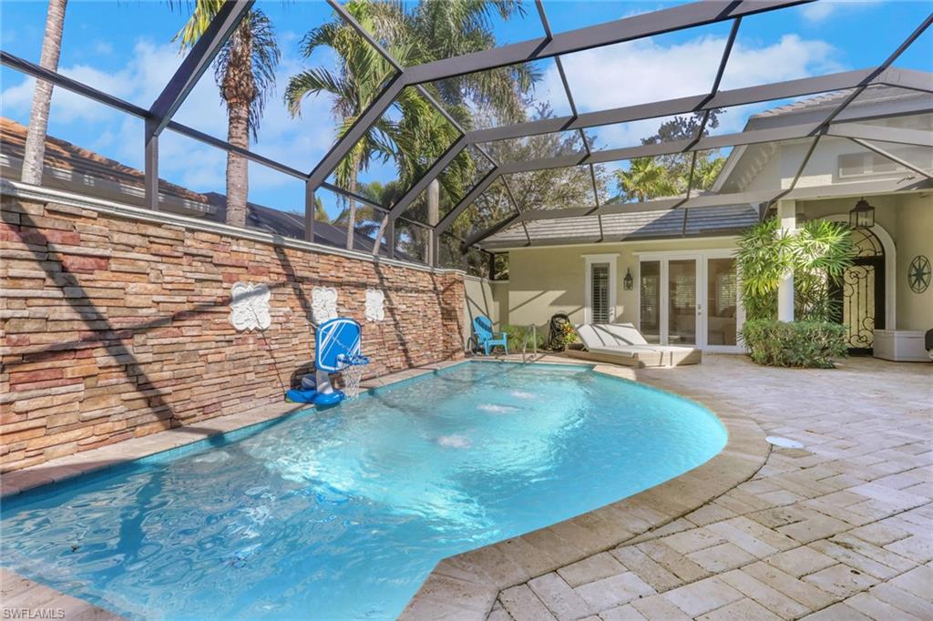 5074 Rustic Oaks Circle Naples, FL 34105 - Photo 32 of 38 Swimming pool with french doors, a sunroom, a lanai, and a patio area