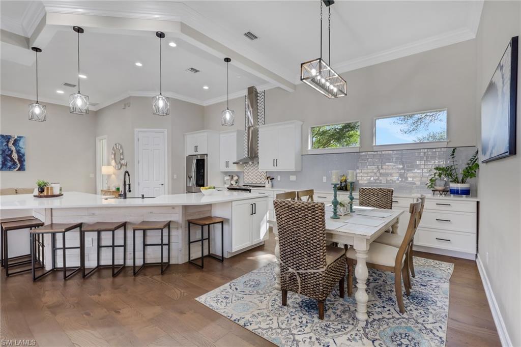 5074 Rustic Oaks Circle Naples, FL 34105 - Photo 5 of 38 Dining room with crown molding and dark wood-style flooring