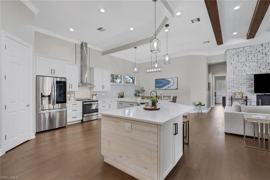 5074 Rustic Oaks Circle Naples, FL 34105 - Photo 38 of 38 Kitchen with white cabinetry, stainless steel appliances, a kitchen breakfast bar, pendant lighting, and open floor plan