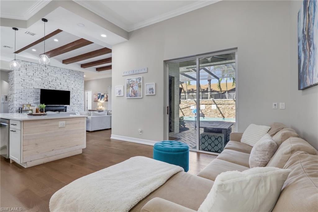 5074 Rustic Oaks Circle Naples, FL 34105 - Photo 9 of 38 Living room with beam ceiling, light wood finished floors, crown molding, and recessed lighting