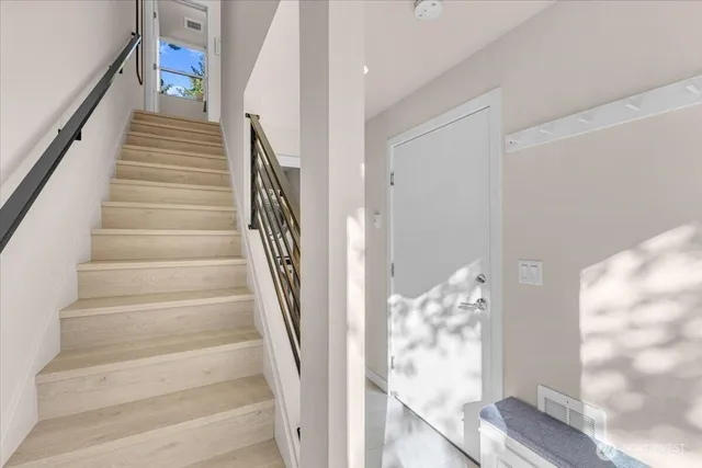 a view of staircase with white walls and windows