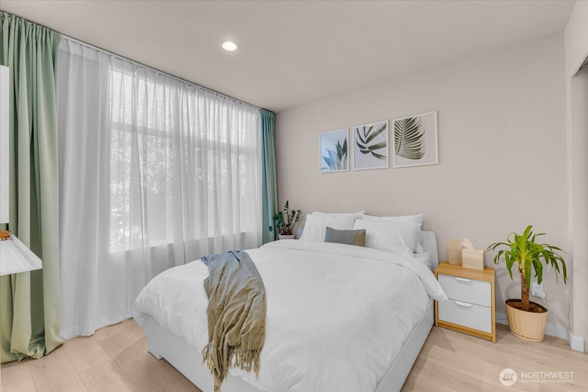 1602 East Marion Street Seattle, WA 98122 - Photo 17 of 28 a bedroom with a bed and a potted plant
