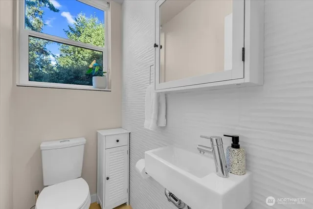 a bathroom with a toilet sink and mirror