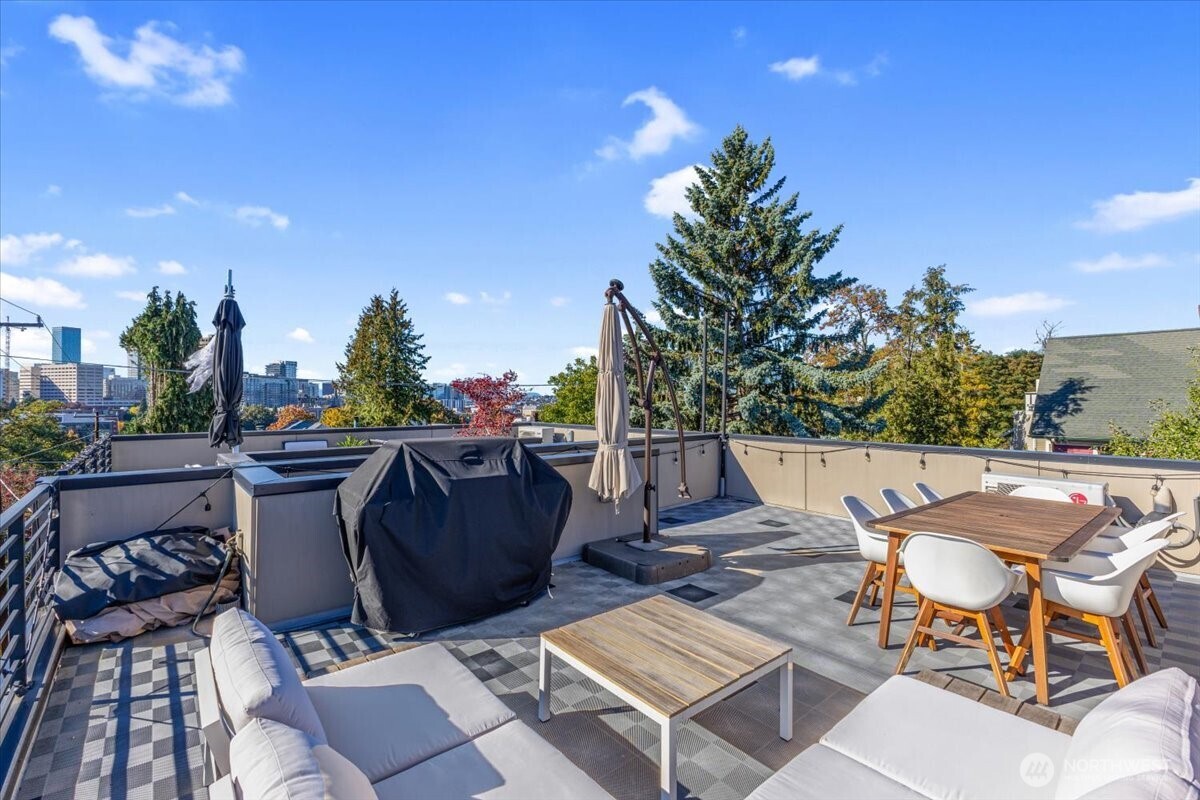 1602 East Marion Street Seattle, WA 98122 - Photo 5 of 28 a view of a patio with table and chairs and potted plants with sky view
