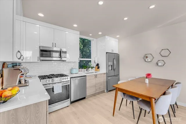 a kitchen with stainless steel appliances granite countertop a stove a sink a microwave a refrigerator and cabinets