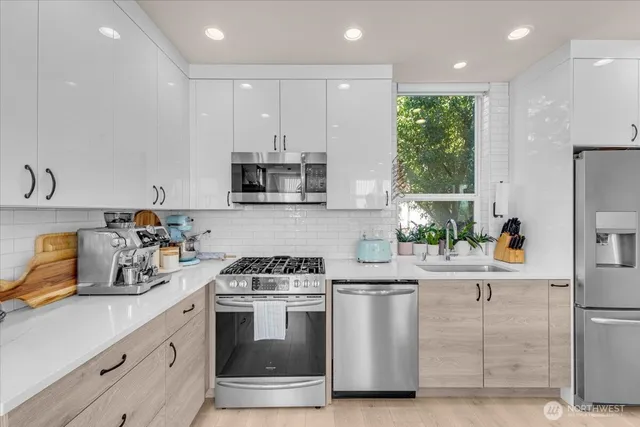 a kitchen with white cabinets and stainless steel appliances