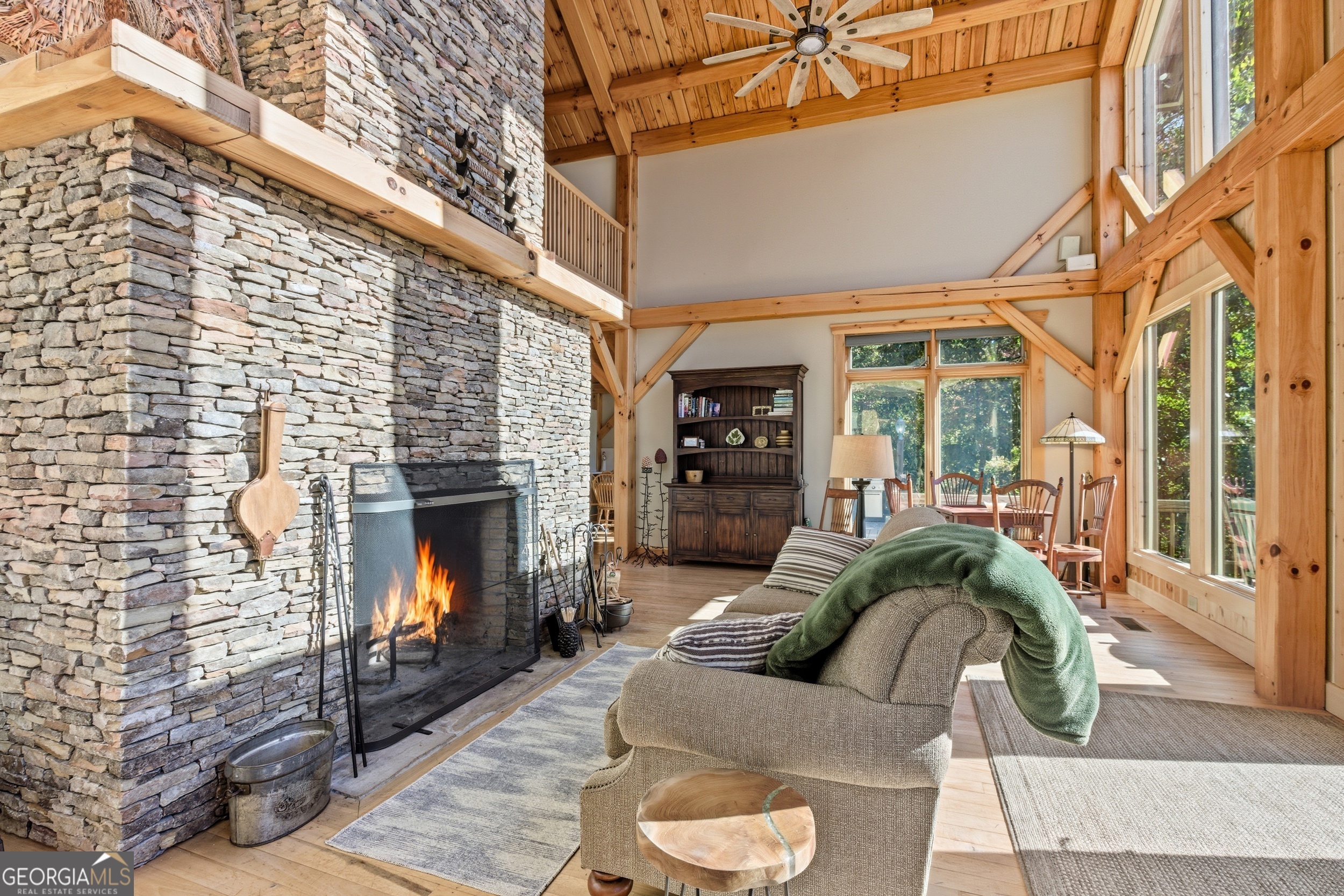 526 Grandaddy Still Road Scaly Mountain, NC 28775 - Photo 18 of 65 a living room with furniture a fireplace and a floor to ceiling window