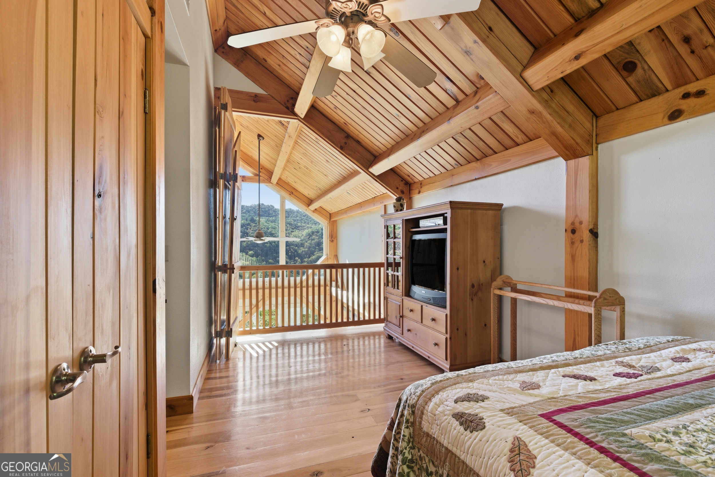 526 Grandaddy Still Road Scaly Mountain, NC 28775 - Photo 33 of 65 a bedroom with a bed and wooden floor