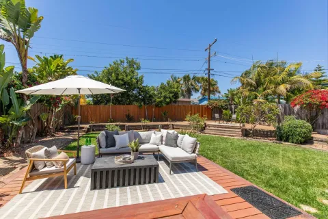 a view of a house with backyard and sitting area