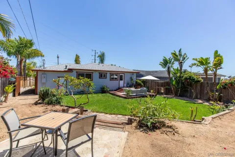 a view of a house with backyard sitting area and swimming pool