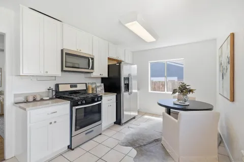 a kitchen with white cabinets and stainless steel appliances