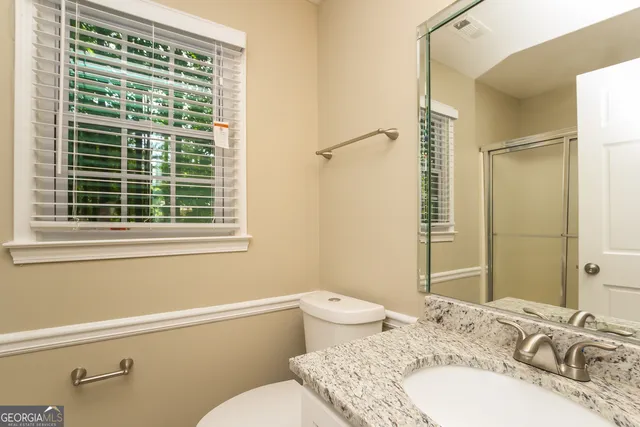 a bathroom with a granite countertop sink toilet and shower